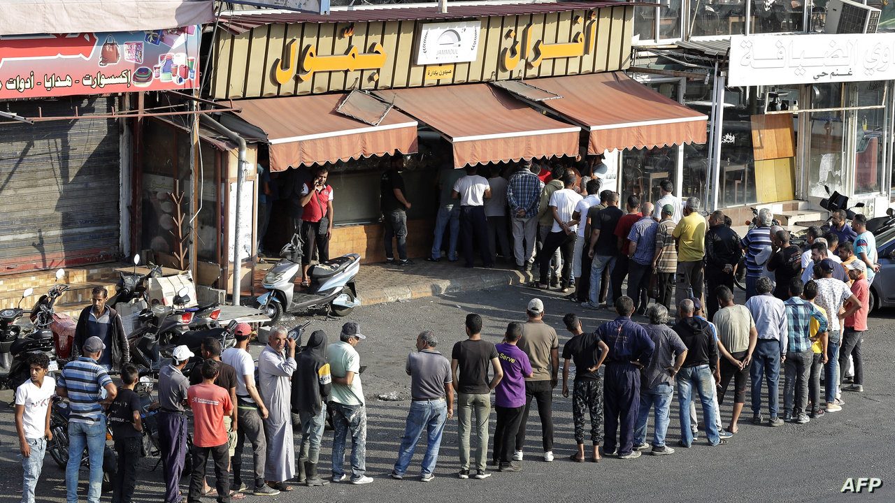 People line up in front of a bakery to buy bread in Lebanon's southern city of Sidon on June 22, 2022 as fuel and wheat shortage deepens. - Lebanon has been battered by triple-digit inflation, soaring poverty rates and the collapse of its currency since a 2020 debt default. (Photo by MAHMOUD ZAYYAT / AFP)