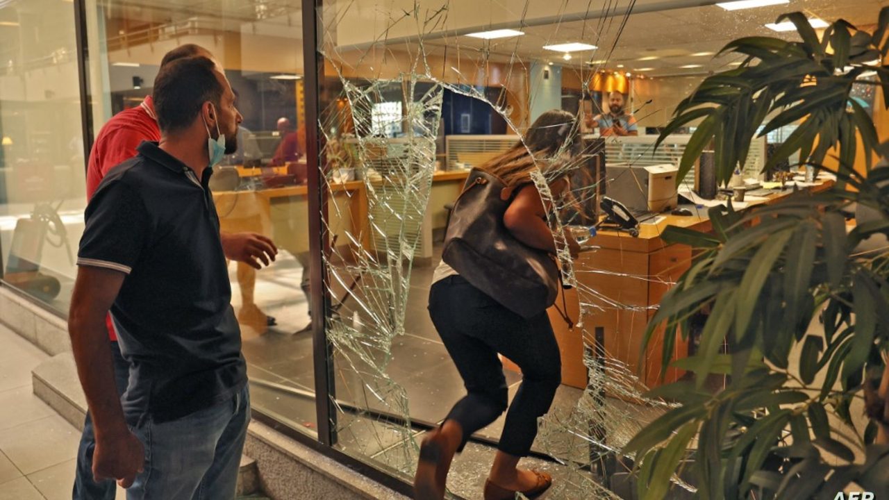 The glass facade of a bank in the Lebanese capital Beirut is broken, after a woman stormed it demanding access to her sister's deposits to allegedly pay for her hospital fees, on September 14, 2022. - Lebanese banks since 2019 have gradually imposed draconian controls on deposits, effectively locking customers out of their foreign currency savings, in a move that has spurred a series of bank heists by Lebanese trying to reclaim access to their money. (Photo by ANWAR AMRO / AFP)