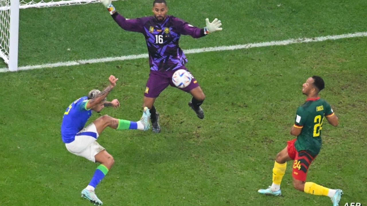 Brazil's midfielder #17 Bruno Guimaraes (L) takes a shot at Cameroon's goalkeeper #16 Devis Epassy nets next to Brazil's defender #24 Bremer (R) during the Qatar 2022 World Cup Group G football match between Cameroon and Brazil at the Lusail Stadium in Lusail, north of Doha on December 2, 2022. (Photo by Antonin THUILLIER / AFP)
