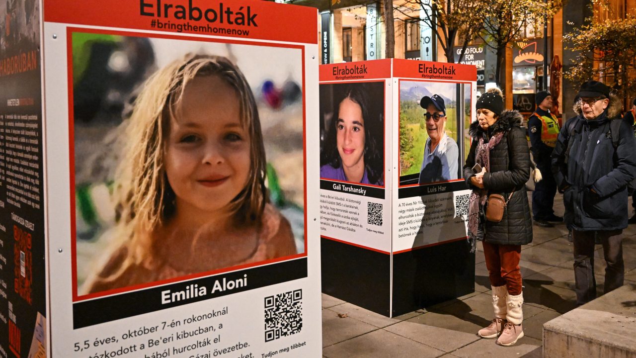 Visitors look at information boards showing photos of Israeli hostages during commemorations for the hostages who have been held in Gaza since the October 7 attack by Hamas militants, in Budapest, Hungary on November 25, 2023. Thousands of civilians, both Palestinians and Israelis, have died since October 7, 2023, after Palestinian Hamas militants based in the Gaza Strip entered southern Israel in an unprecedented attack triggering a war declared by Israel on Hamas with retaliatory bombings on Gaza. (Photo by ATTILA KISBENEDEK / AFP)