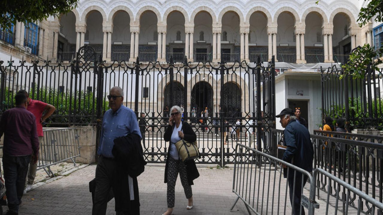 People walk in front of the Tunis Court on May 13, 2024, as the Tunisian bar association declares a strike and boycott of hearings to protest security forces storming its premises to make arrests a couple of days earlier. Tunisian authorities ordered on May 12 the arrest of two political commentators over critical comments, a lawyer told AFP, a day after security forces stormed the bar association and took a third pundit into custody. (Photo by FETHI BELAID / AFP)