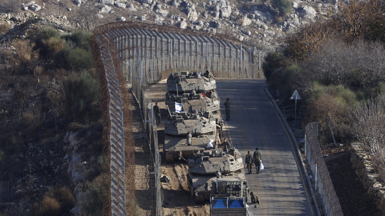 Israeli tanks take position on the border with Syria near the Druze village of Majdal Shams in the Israel-annexed Golan Heights on December 8, 2024. The Israeli military said on December 8, it had deployed forces to a demilitarised buffer zone in southwest Syria abutting the Israeli-annexed Golan Heights after Damascus fell to rebel forces. (Photo by Jalaa MAREY / AFP)