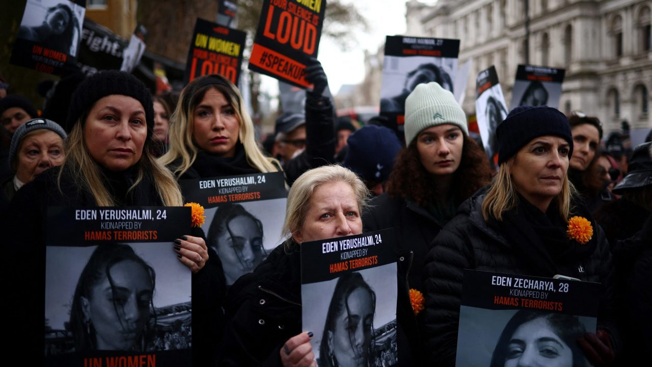 Demonstrators hold posters reading "UN Women, your silence is loud" along pictures of Israeli women being held hostage in Gaza during a rally in London on December 3, 2023 to protest against what they consider a conspiracy of silence over alleged rapes and other sexual crimes committed by Hamas militants during the October 7 attacks. - Israel and Hamas fought for a third day since a seven-day truce expired. Hamas militants from Gaza launched an unprecedented attack on southern Israel on October 7, killing about 1,200 people, mostly civilians, and taking around 240 hostages, according to Israeli officials. In response, Israel vowed to destroy Hamas and began an air, sea and ground offensive that has killed more than 15,200 people, mostly women and children, according to Gaza's Hamas government. (Photo by HENRY NICHOLLS / AFP)
