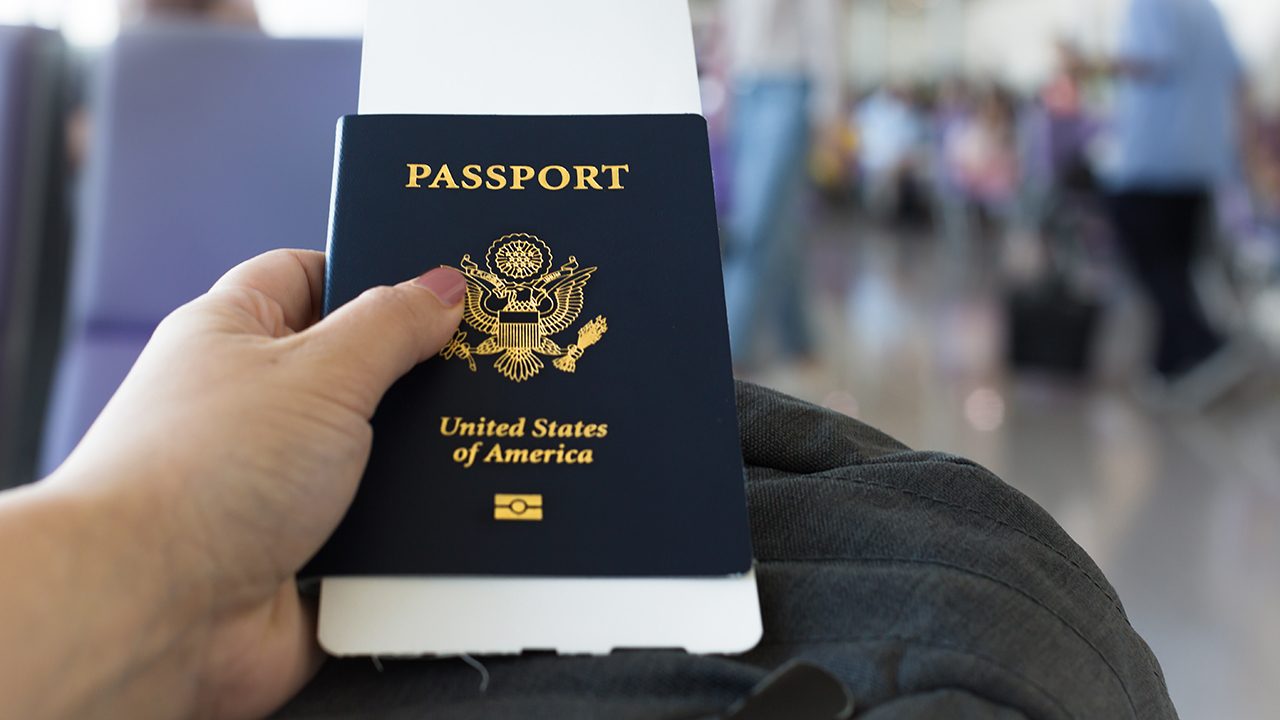A passenger waitng at the airport boarding gate with her passport and ticket in her hand.; Shutterstock ID 1469508770; purchase_order: CCG; job: ; client: ; other: