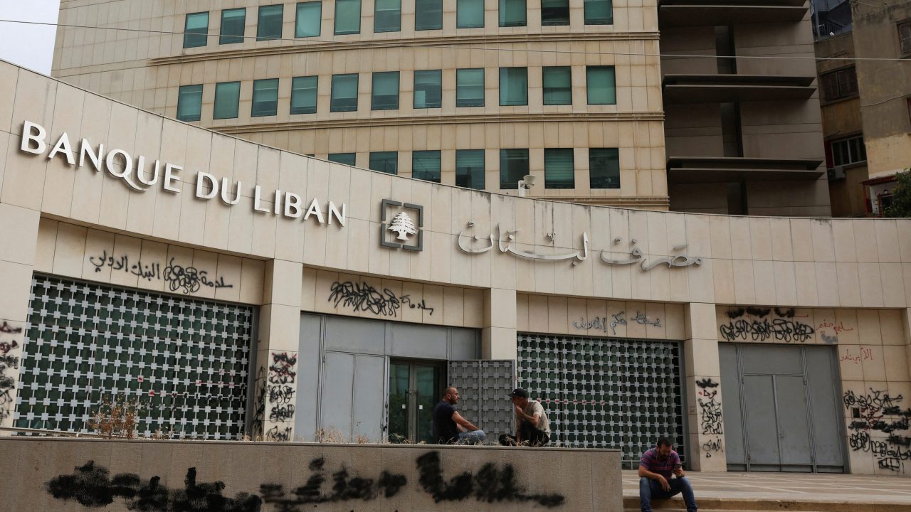 FILE PHOTO: People sit near Lebanon's Central Bank building in Beirut, Lebanon, July 6, 2023. REUTERS/Mohamed Azakir/File Photo