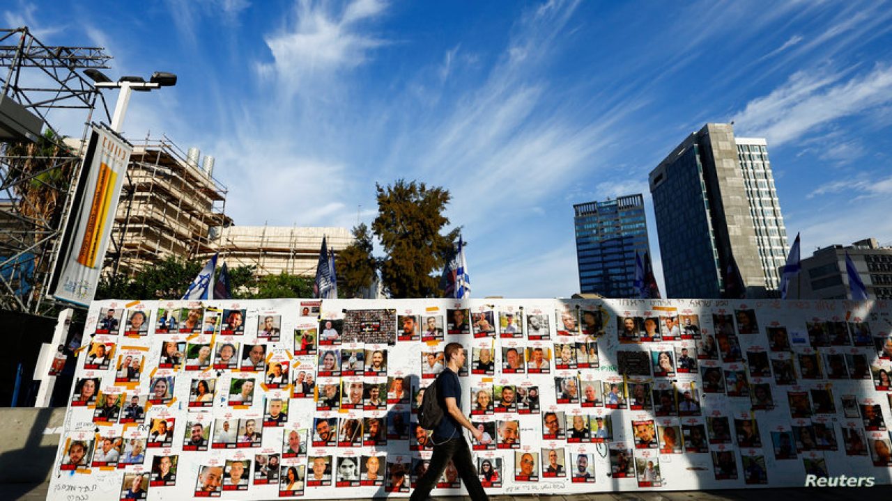 A man walks past posters on a message board with pictures of hostages, who are being held in the Gaza Strip after they were seized by Hamas gunmen on October 7, as the country observes the Jewish festival Hanukkah amid the ongoing conflict between Israel and the Palestinian Islamist group Hamas, in Tel Aviv, Israel December 7, 2023. REUTERS/Clodagh Kilcoyne
