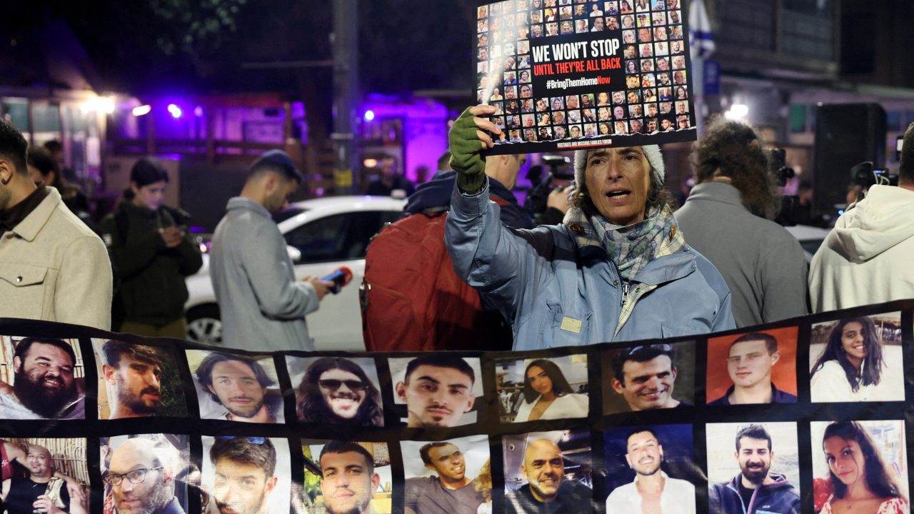 FILE PHOTO: A person holds a placard, as families of hostages and supporters protest to call for the immediate release of hostages kidnapped during the deadly October 7 attack by Palestinian Islamist group Hamas, outside Israeli Prime Minister Benjamin Netanyahu residence, in Jerusalem January 21, 2024. REUTERS/Ronen Zvulun/File Photo