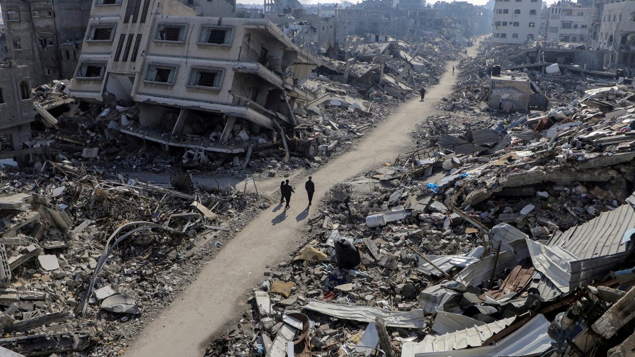 FILE PHOTO: Palestinians walk past destroyed houses, amid the ongoing conflict between Israel and Hamas, in Jabalia refugee camp, in the northern Gaza Strip February 22, 2024. REUTERS/Mahmoud Issa/File Photo