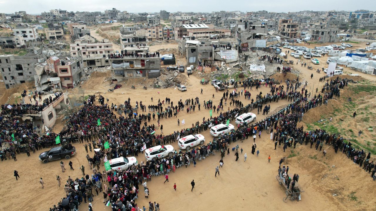 A drone view shows Palestinians and militants gathering around Red Cross vehicles on the day Hamas hands over the bodies of deceased hostages Oded Lifschitz, Shiri Bibas and her two children Kfir and Ariel Bibas, seized during the deadly October 7, 2023 attack, as part of a ceasefire and hostages-prisoners swap deal between Hamas and Israel, in Khan Younis in the southern Gaza Strip, February 20, 2025. REUTERS/Stringer