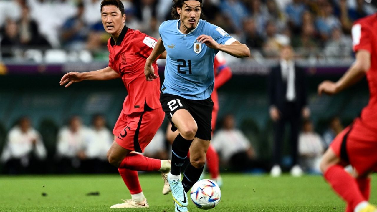 Uruguay's forward #21 Edinson Cavani (C) runs away from South Korea's midfielder #05 Jung Woo-young (L) during the Qatar 2022 World Cup Group H football match between Uruguay and South Korea at the Education City Stadium in Al-Rayyan, west of Doha on November 24, 2022. (Photo by Jewel SAMAD / AFP)