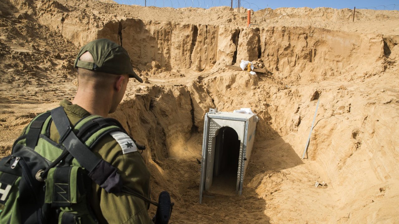 A picture taken on January 18, 2018 from the Israeli side of the border with the Gaza Strip shows a Israeli army officer walking near the entrance of a tunnel, that Israel says was dug by the Islamic Jihad group, leading from the Palestinian enclave into Israel, near southern Israeli kibbutz of Kissufim.
Israel uncovered and destroyed the tunnel in late October. / AFP PHOTO / POOL / JACK GUEZ