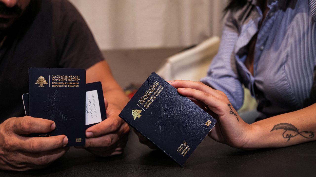 Nanor Abachian (R) and her husband Shadi Abi Haidar look at their Lebanese passports at their home in Beirut's Naccache area, on August 31, 2021, as they prepare to emigrate to Cyprus. - Just as during the 1975-1990 civil war that ravaged their country, hundreds of Lebanese families are turning to neighbouring Cyprus to escape the miseries of everyday life back home. Short-haul flights from Beirut to Larnaca, barely a 25-minute hop away, have been busy for months ferrying in Lebanese for whom their crisis-hit country with its dire shortages has become unliveable. (Photo by ANWAR AMRO / AFP) (Photo by ANWAR AMRO/AFP via Getty Images)