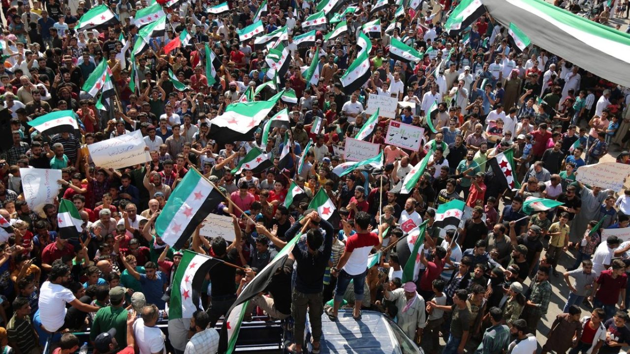FILED - 21 September 2018, Syria, Saraqib: Syrian protesters take part in a demonstration against the Syrian regime of Bashar al-Assad. Demonstrators protesting against hardship in southern Syria vented their anger on Wednesday by gathering at offices of the ruling Baath Party there and burning pictures of President Bashar al-Assad, activists said. Photo: Anas ALkharboutli/dpa