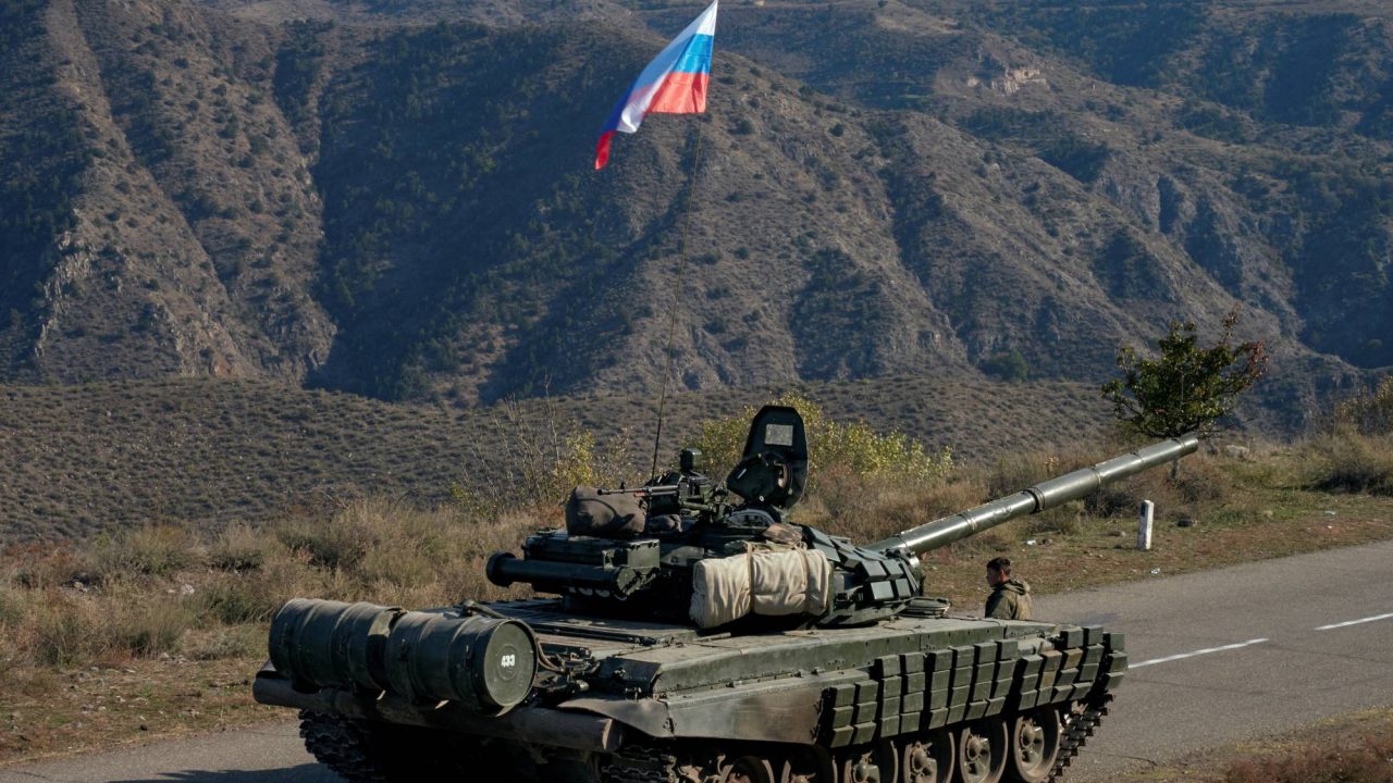 FILE PHOTO: A service member of the Russian peacekeeping troops stands next to a tank near the border with Armenia, following the signing of a deal to end the military conflict between Azerbaijan and ethnic Armenian forces, in the region of Nagorno-Karabakh, November 10, 2020. REUTERS/Francesco Brembati/File Photo