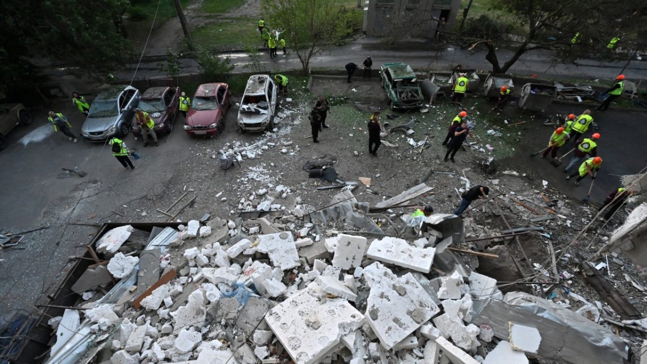 City workers clean the floor outside a multi-storey residential building damaged during a Russian drones strike overnight in Kharkiv on June 12, 2025, amid Russian invasion in Ukraine. Russian night-time strikes on Ukraine's Kharkiv wounded 14 people, including four children, Ukraine said today, in the latest heavy bombardment of the northeastern city. (Photo by SERGEY BOBOK / AFP)