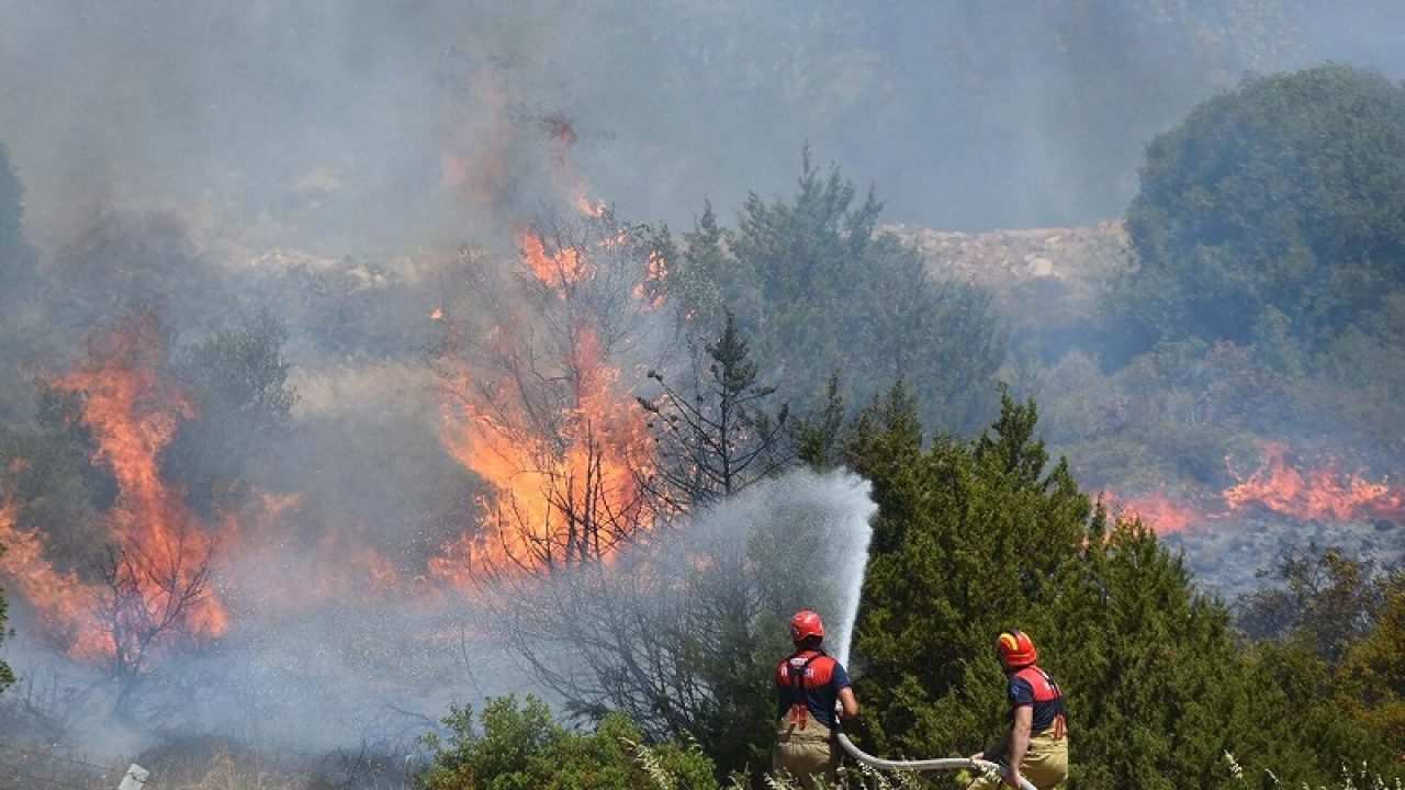 This handout photograph taken and released on July 3, 2025 by Turkish news agency DHA (Demiroren News Agency) shows firefighters working to extinguish a wildfire in Izmir. (Photo by HANDOUT / DHA (Demiroren News Agency) / AFP) / Turkey OUT / TURKEY OUT / TURKEY OUT / RESTRICTED TO EDITORIAL USE - MANDATORY CREDIT "AFP PHOTO /  DHA (DEMIROREN NEWS AGENCY) " - NO MARKETING NO ADVERTISING CAMPAIGNS - DISTRIBUTED AS A SERVICE TO CLIENTS