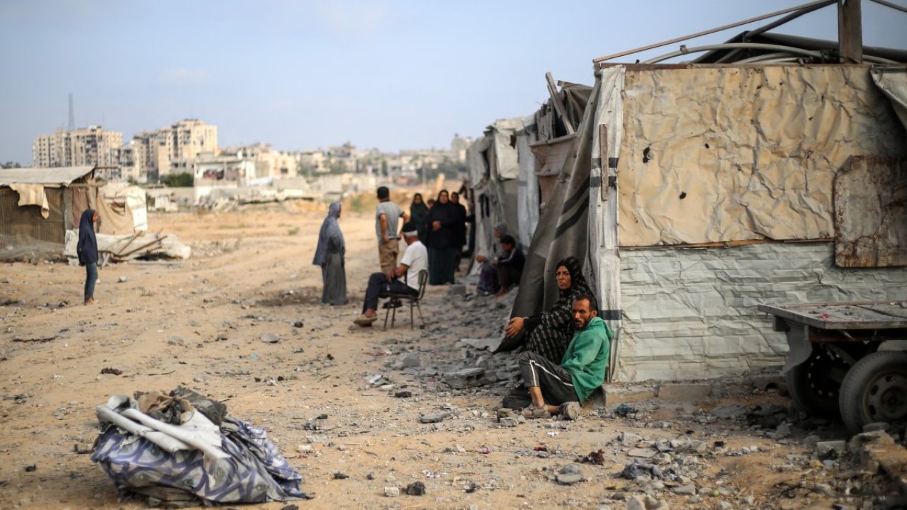 Palestinians sit in front of their makeshift home in the Bureij refugee camp in the central Gaza Strip on July 10, 2025. (Photo by Eyad BABA / AFP)