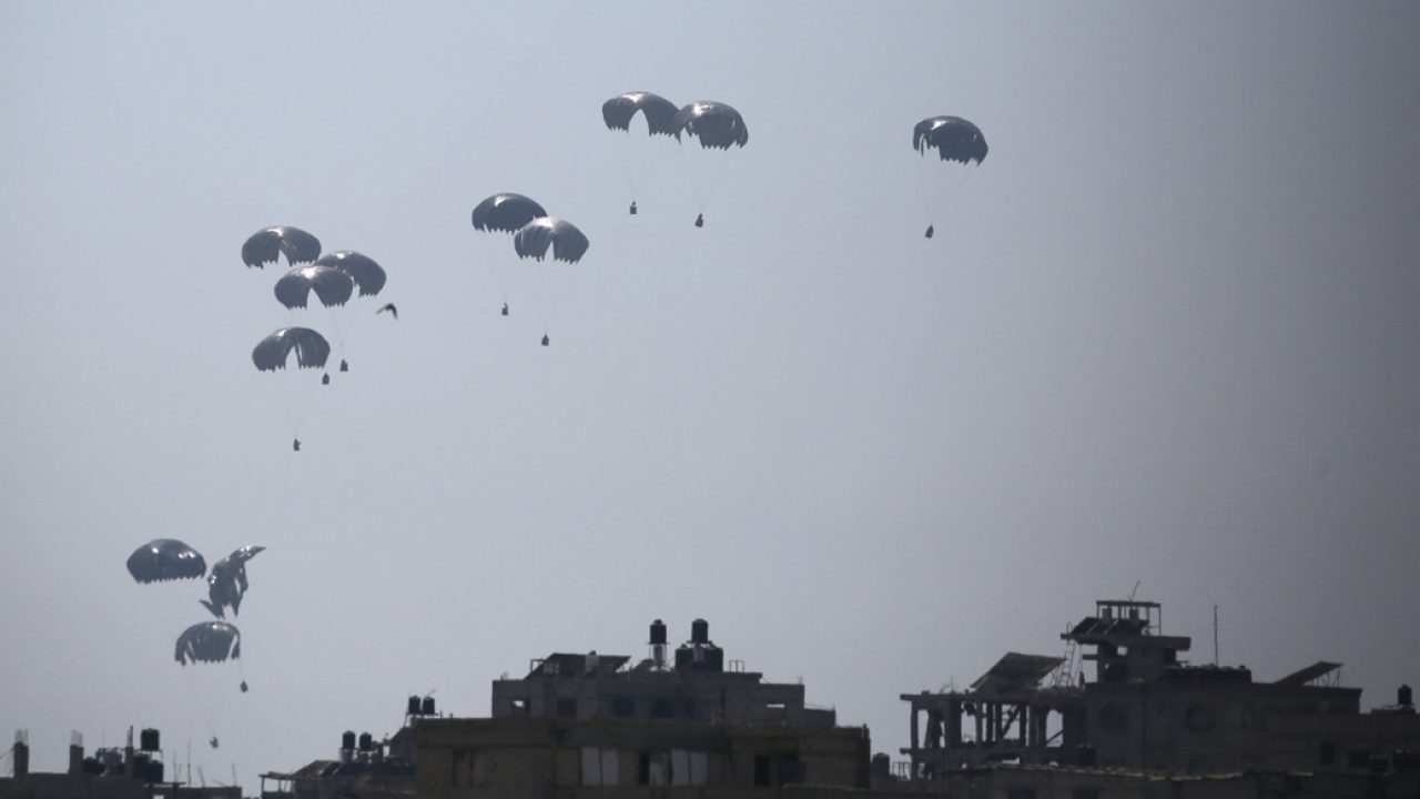 A military transport aircraft drops humanitarian aid over Al-Zawayda, in the central Gaza Strip, on July 28, 2025. (Photo by Eyad BABA / AFP)