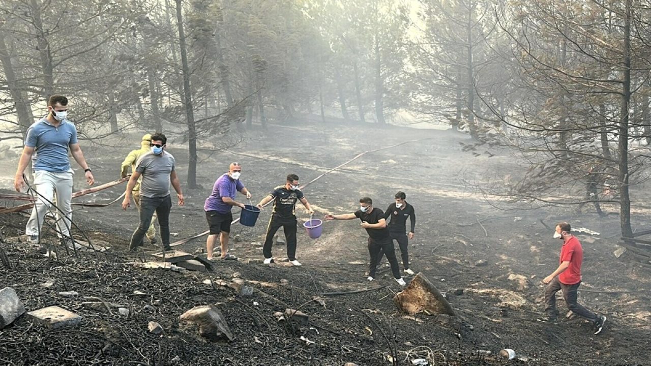 This handout photograph taken and released on August 8, 2025 by Turkish news agency DHA (Demiroren News Agency) shows people working to extinguish wildfire in Canakkale, northwestern Turkey in the Marmara region. Wildfires in Turkey forced authorities to suspend shipping in the busy Dardanelles Strait and evacuate hundreds of people on Friday as firefighters battled the blazes, officials said. Turkey "temporarily" shut the strait in both directions, the transport ministry said, after fires broke out in the northwestern province of Canakkale and spread, fanned by strong winds. (Photo by HANDOUT / DHA (Demiroren News Agency) / AFP) / TURKEY OUT / RESTRICTED TO EDITORIAL USE - MANDATORY CREDIT "AFP PHOTO / DHA (DEMIROREN NEWS AGENCY) " - NO MARKETING NO ADVERTISING CAMPAIGNS - DISTRIBUTED AS A SERVICE TO CLIENTS