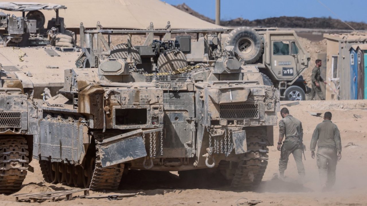 Israeli soldiers carry out maintenance on tanks positioned in southern Israel, on the border with the Gaza Strip on October 11, 2025. Israel declared a ceasefire in Gaza and began to pull back its forces on October 10, as tens of thousands of exhausted Palestinians made their way back to their devastated homes. (Photo by Menahem KAHANA / AFP)