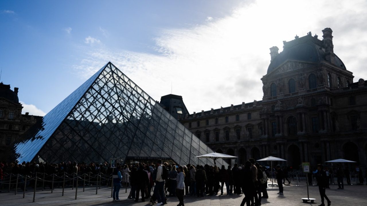 Tourists queue to enter the Louvre museum next to the Louvre pyramid designed by Chinese-US architect Ieoh Ming Pei, in Paris, on November 3, 2025. (Photo by Julie SEBADELHA / AFP) / RESTRICTED TO EDITORIAL USE - MANDATORY MENTION OF THE ARTIST UPON PUBLICATION - TO ILLUSTRATE THE EVENT AS SPECIFIED IN THE CAPTION