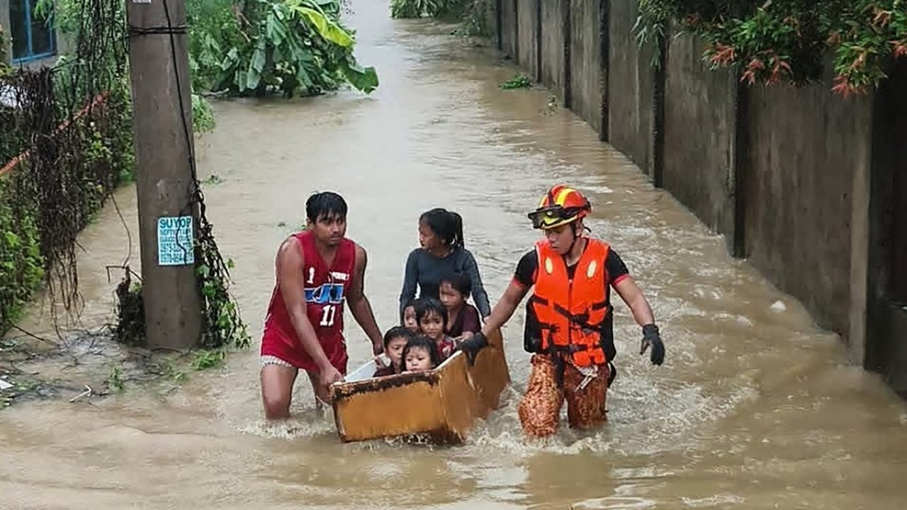 This handout photo taken and released on November 4, 2025 by the Bureau Fire Protection-Toledo City station shows personnel help evacuate people on a makeshift boat made from a discarded refrigerator from their flooded homes following heavy rains brought about by Typhoon Kalmaegi in Toledo City, Cebu province, central Philippines. Residents sought refuge on rooftops and cars floated through flooded streets on November 4 as Typhoon Kalmaegi battered the central Philippines, leaving at least two people dead. (Photo by Handout / BUREAU OF FIRE PROTECTION-TOLEDO CITY / AFP) / RESTRICTED TO EDITORIAL USE - MANDATORY CREDIT "AFP PHOTO / BUREAU OF FIRE PROTECTION-TOLEDO CITY" - HANDOUT - NO MARKETING NO ADVERTISING CAMPAIGNS - DISTRIBUTED AS A SERVICE TO CLIENTS