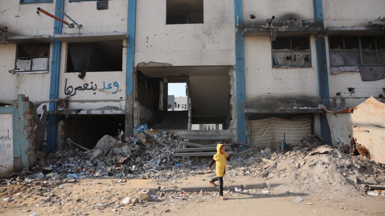 A girl walks near a camp for displaced Palestinians at a school-turned-shelter in Al-Rimal neighbourhood of Gaza City on November 5, 2025. (Photo by Omar AL-QATTAA / AFP)