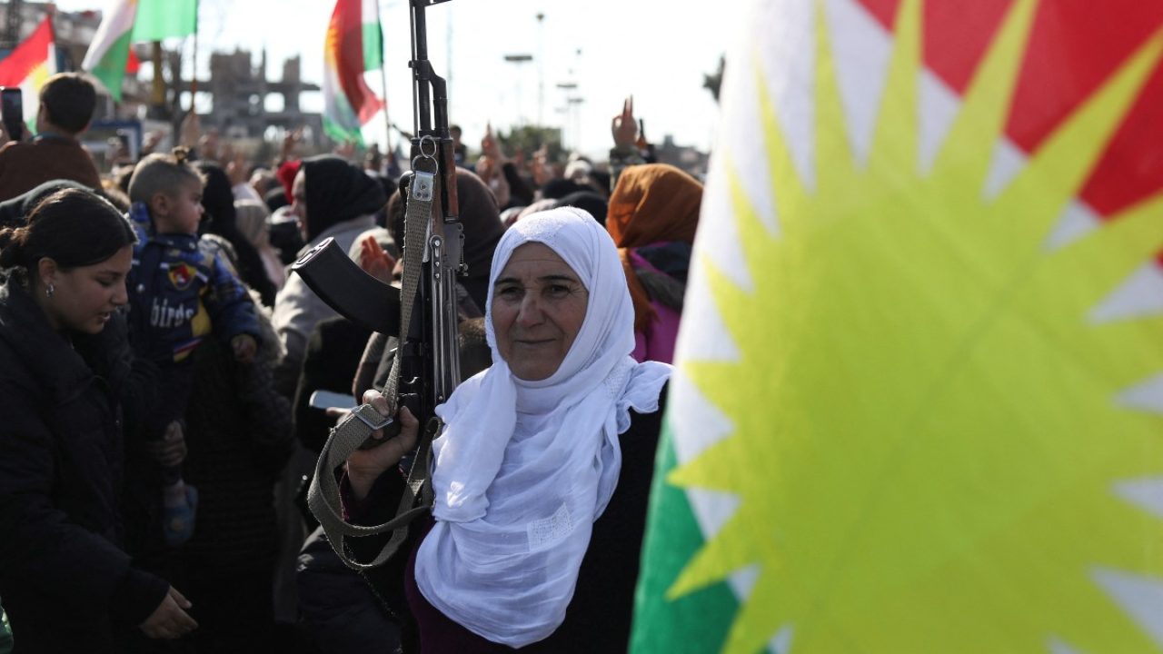 Kurdish civilians gather with their weapons in the city of Qamishli on January 20, 2026 as the Kurdish-led Syrian Democratic Forces (SDF) called for "young Kurds, men and women" both within and outside Syria to "join the ranks of the resistance". Negotiations have collapsed between the Syrian president and the chief of the country's Kurdish-led forces, a Kurdish official told AFP, as the army deployed reinforcements to flashpoint areas in the north. (Photo by Delil SOULEIMAN / AFP)