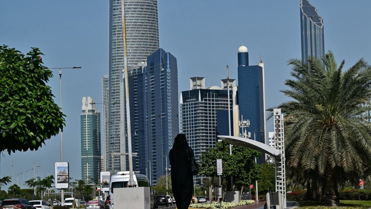 A woman walks along a street in Abu Dhabi on February 4, 2026. Moscow on February 4, demanded Kyiv accept its conditions to end the four-year-war and vowed to press on with its invasion otherwise, as negotiations between the two sides opened in Abu Dhabi. (Photo by Giuseppe CACACE / AFP)