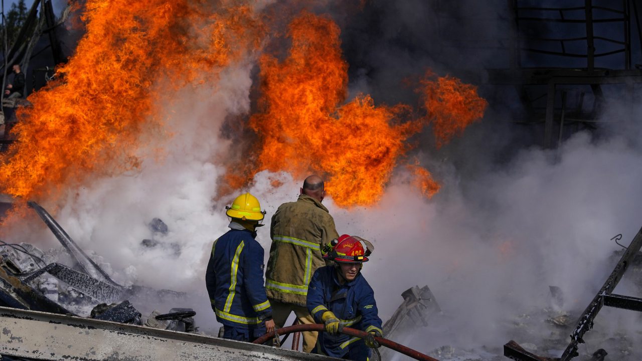 Firefighters extinguish a fire at a destroyed warehouse that was targeted on Monday by Israeli airstrikes, at an industrial district in the southern coastal town of Ghazieh, Lebanon, Tuesday, Feb. 20, 2024. Israeli warplanes on Monday carried out at least two strikes near the southern port city of Sidon in one of the largest attacks near a major city, wounding 14 people, Lebanese state media said. (AP Photo/Bilal Hussein)