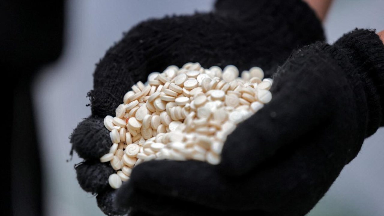 An officer of the Directorate of Narcotics Control of Saudi Arabia's Interior Ministry holds a handful of tablets of captagon (Fenethylline) seized in Jeddah on March 1, 2022