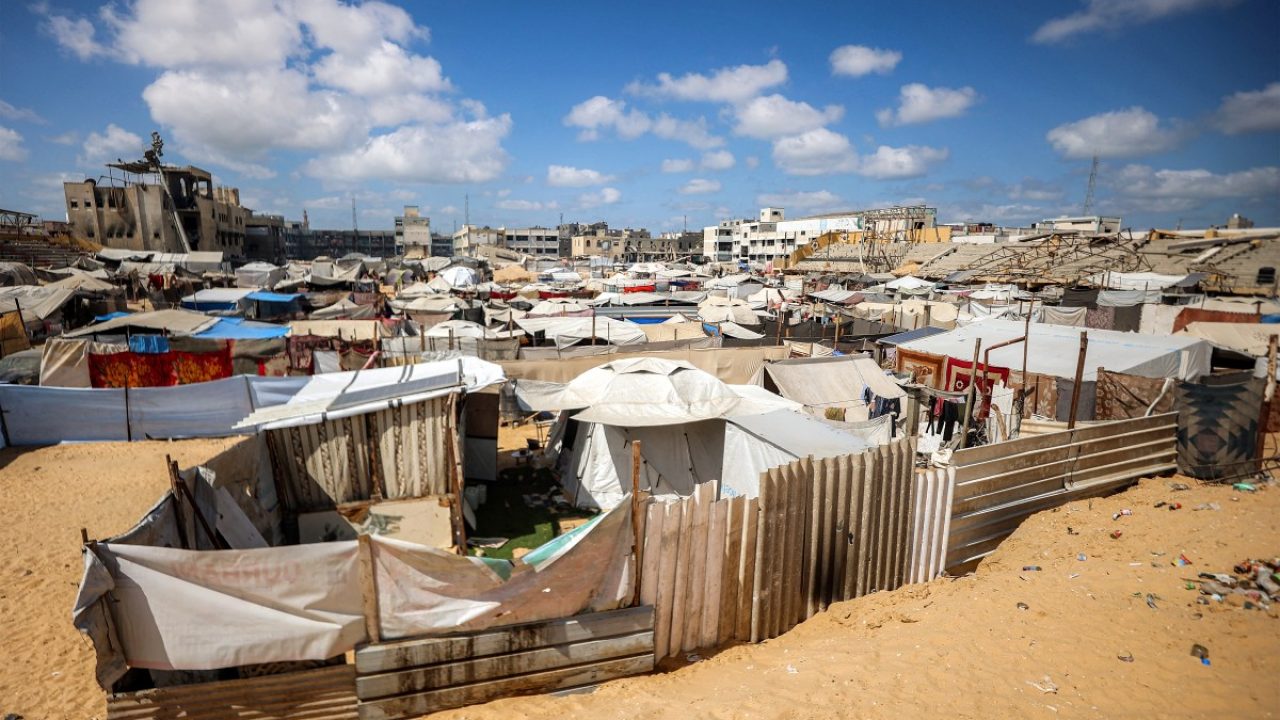 Tents at a make-shift camp for people displaced by conflict are pictured in the football pitch of a school run by the United Nations Relief and Works Agency for Palestine Refugees (UNRWA), in Khan Yunis in the southern Gaza Strip on September 30, 2025. Hamas was reviewing Donald Trump's plan for Gaza on September 30, while the Israeli prime minister said the military would stay in most of the territory after he gave the US president his backing. The plan calls for a ceasefire, release of hostages by Hamas within 72 hours, disarmament of Hamas and gradual Israeli withdrawal from Gaza, followed by a post-war transitional authority headed by Trump himself. (Photo by Omar AL-QATTAA / AFP)
