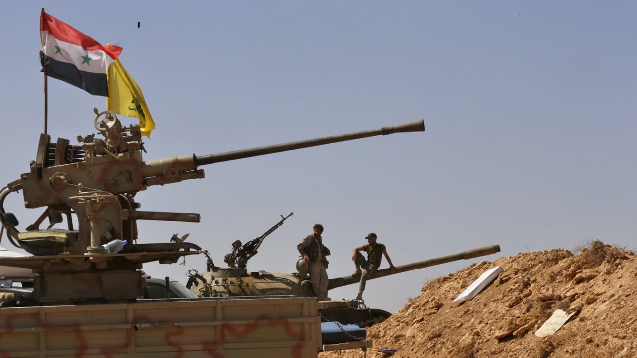 Syrian forces members stand on a tank next to vehicles waiting to transport Islamic State (IS) group members in the Qara area in Syria's Qalamoun region on August 28, 2017 as part of a deal between Hezbollah and IS fighters where the jihadists would leave to eastern Syria.
Syria's state news agency SANA, quoting a military source, confirmed Hezbollah and IS had agreed that "the remaining Daesh (IS) fighters will leave to eastern Syria". And a Lebanese military source told AFP the jihadist group would quit territory it held in eastern Lebanon.
 / AFP PHOTO / Louai Beshara        (Photo credit should read LOUAI BESHARA/AFP/Getty Images)