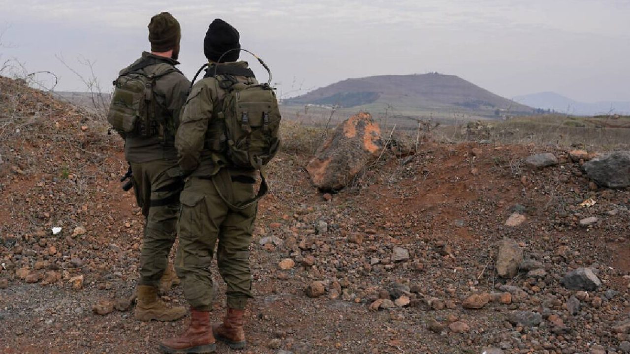 Israeli soldiers looking at syria