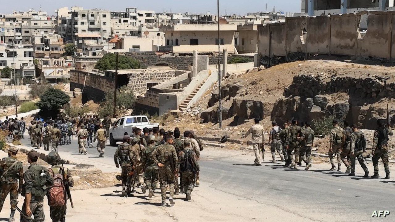 A handout picture released by the official Syrian Arab News Agency (SANA) on September 8, 2021 shows Syrian army entering the rebel-held Daraa al-Balad district of Daraa city under a ceasefire deal brokered by government ally Russia. - Daraa province and its capital of the same name, the cradle of Syria's uprising, returned to government control in 2018 under a previous Moscow-backed ceasefire. But rebels remained in some areas, including the southern part of the city called Daraa al-Balad. (Photo by SANA / AFP) / == RESTRICTED TO EDITORIAL USE - MANDATORY CREDIT "AFP PHOTO / HO / SANA" - NO MARKETING NO ADVERTISING CAMPAIGNS - DISTRIBUTED AS A SERVICE TO CLIENTS ==