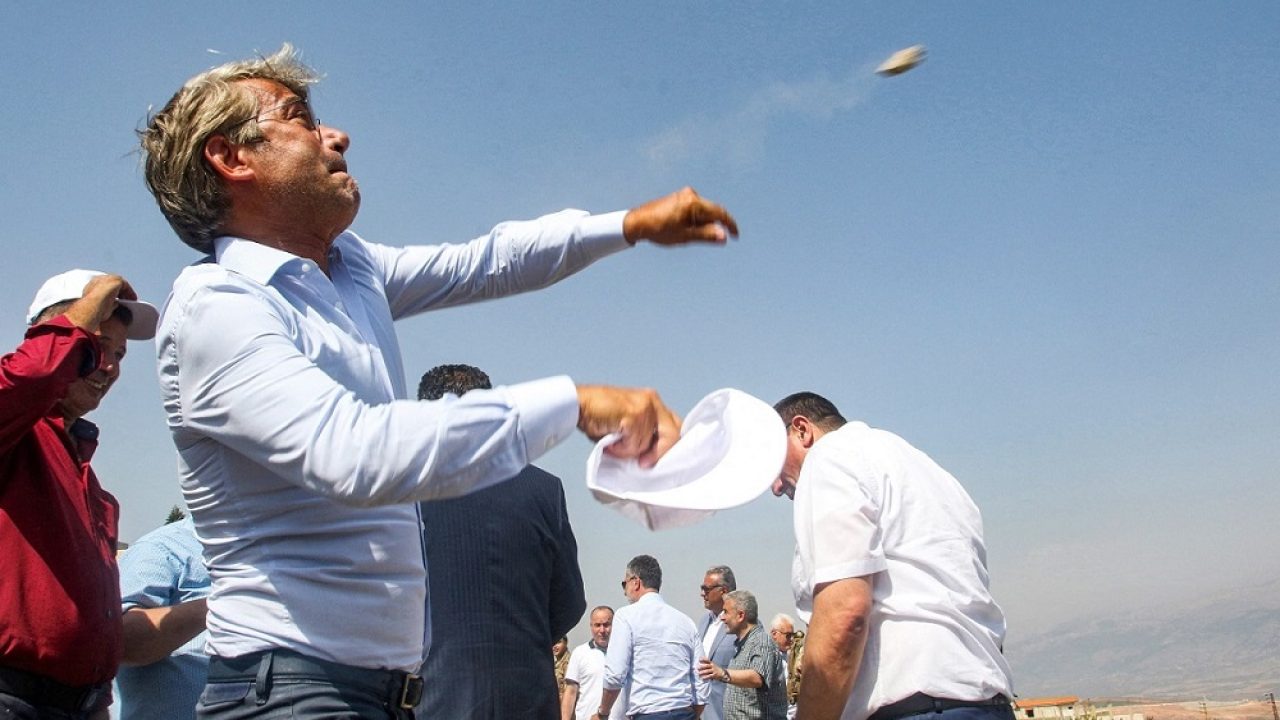 LEBANON-ISRAEL-CONFLICT-BORDER Walid Fayyad, Lebanon's Energy Minister, throws a stone during a visit to a position along the border with Israel on the outskirts of the southern village of Adaisseh on August 30, 2022. (Photo by Mahmoud ZAYYAT / AFP)