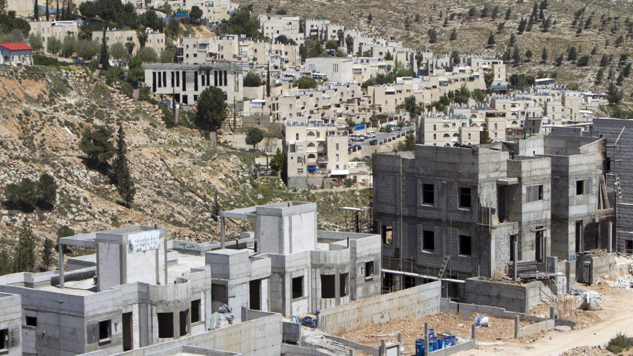 A general view taken on April 8, 2014 shows construction at a building site of new housing units in the Jewish settlement of Neve Yaakov, near Israel's controversial separation wall in the northern area of east Jerusalem. Israel has pushed forward plans for several thousand new settlement homes in the West Bank during faltering negotiations that US Secretary of State John Kerry kick-started in July. AFP PHOTO/AHMAD GHARABLI