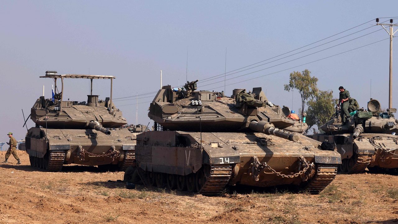 Israeli troops and tanks gather near the border with the Gaza Strip on December 3, 2023, after battles resumed between Israel and Hamas militants, as clashes continue between Israel and Hamas militants on December 3, 2023. Israel carried out deadly bombardments in Gaza on December 3 as international calls mounted for greater protection of civilians and the renewal of an expired truce with Palestinian militant group Hamas. (Photo by JACK GUEZ / AFP)