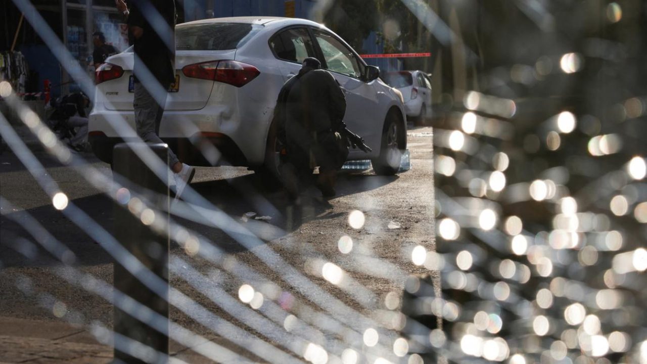Police officers looking for evidence are seen through a damaged window glass at the site of an explosion, amid the Israel-Hamas conflict in Tel Aviv, Israel July 19, 2024. REUTERS/Ricardo Moraes