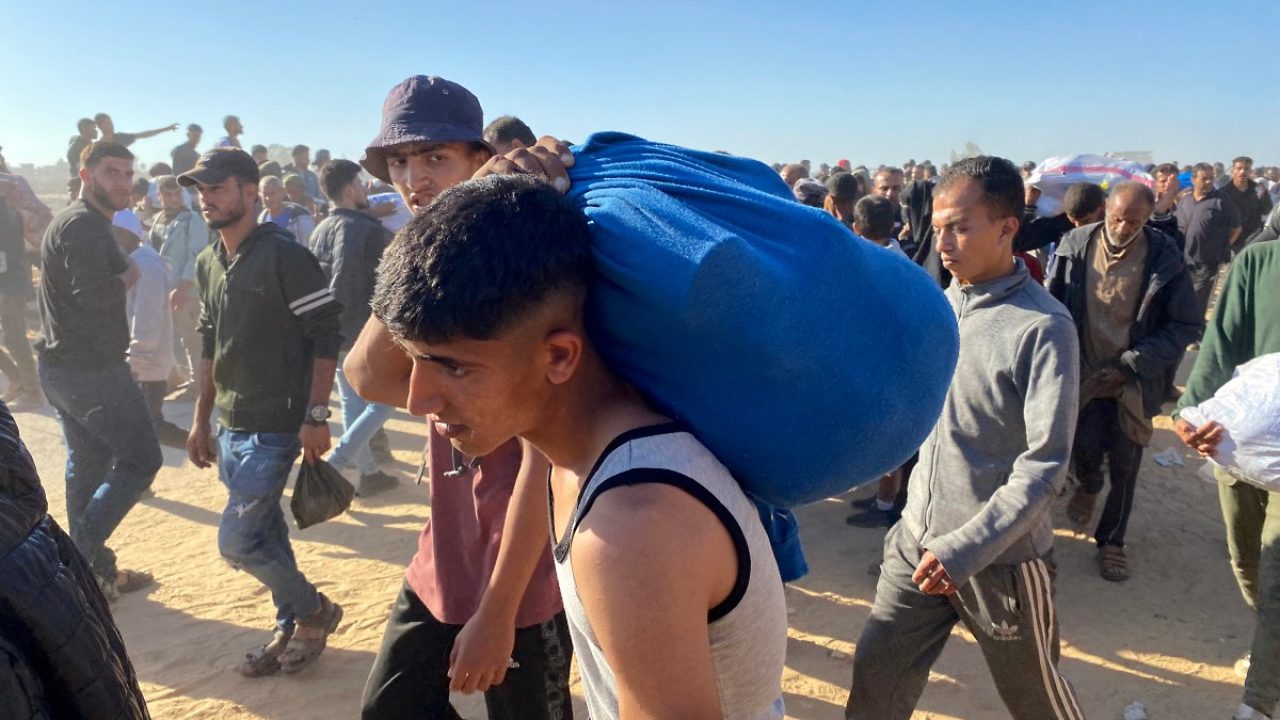 Displaced Palestinians carrying relief supplies return from aid distribution centres in Rafah to their tents in the southern Gaza Strip on May 29, 2025. The humanitarian situation in Gaza, where aid has finally begun to trickle in after a two-month blockade, is dire following 18 months of devastating war between Israel and Palestinian Hamas movement. Food security experts say starvation is looming for one in five people. (Photo by AFP)
