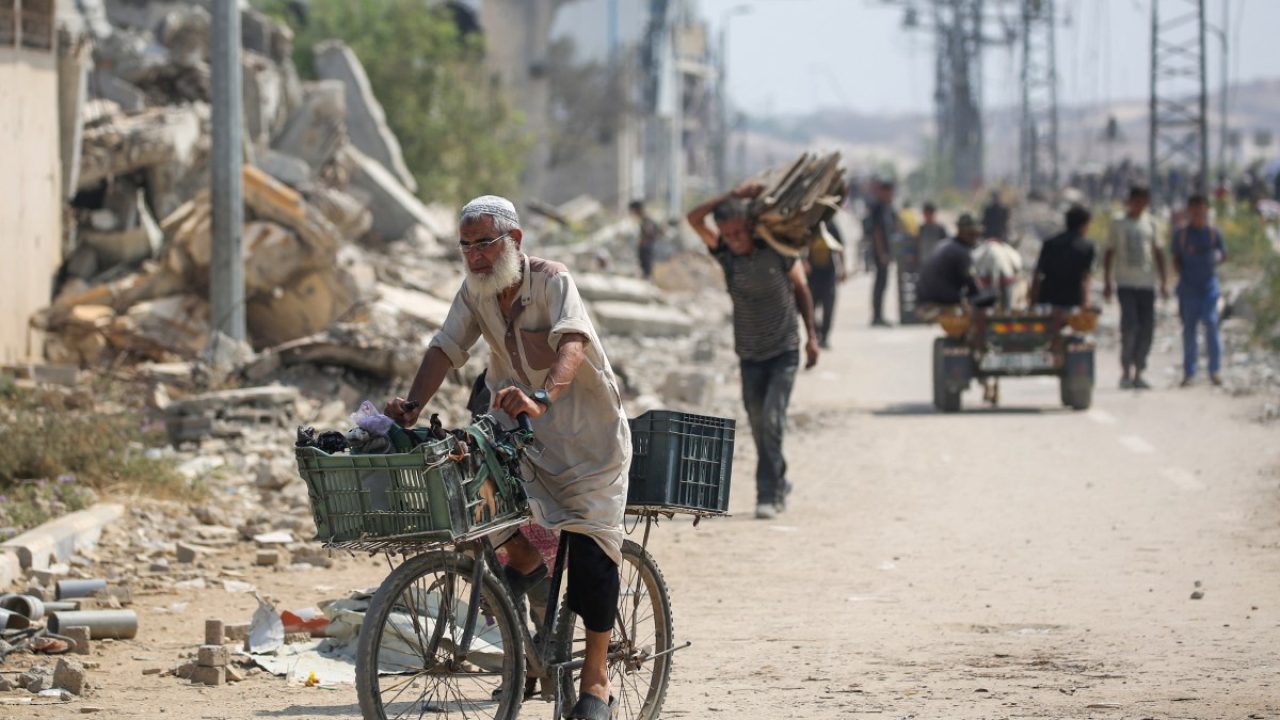 Displaced Palestinians at the Nuseirat refugee camp haul food parcels and other items they managed to get from a GHF aid distribution point at the so-called "Netzarim corridor" in the central Gaza Strip on July 26, 2025. (Photo by Eyad BABA / AFP)