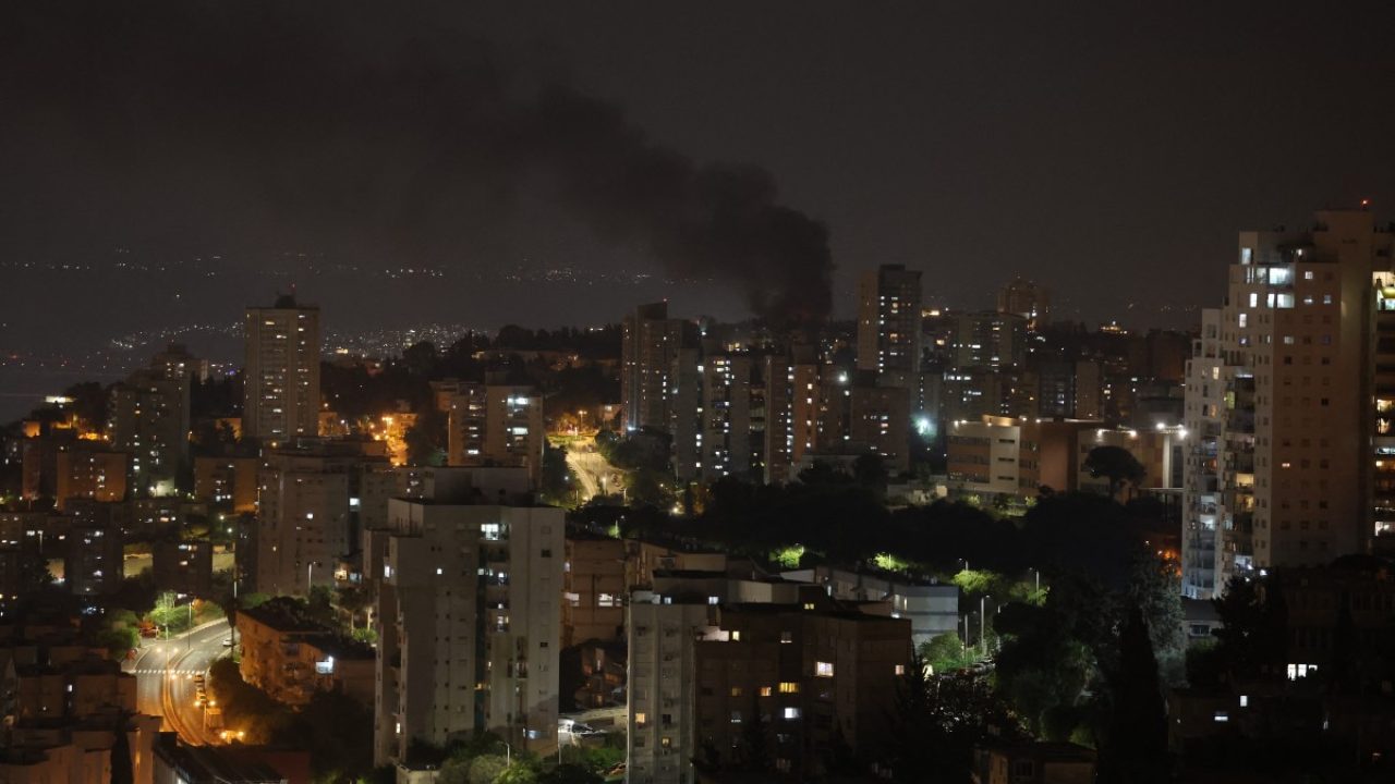 Smoke billows from a site in the city of Haifa following a fresh barrage of Iranian missile attacks on June 15, 2025. Israel and Iran traded heavy fire for a third straight day on June 15, with mounting casualties and expanding targets marking a sharp escalation in hostilities between the longtime foes. (Photo by Ahmad GHARABLI / AFP)