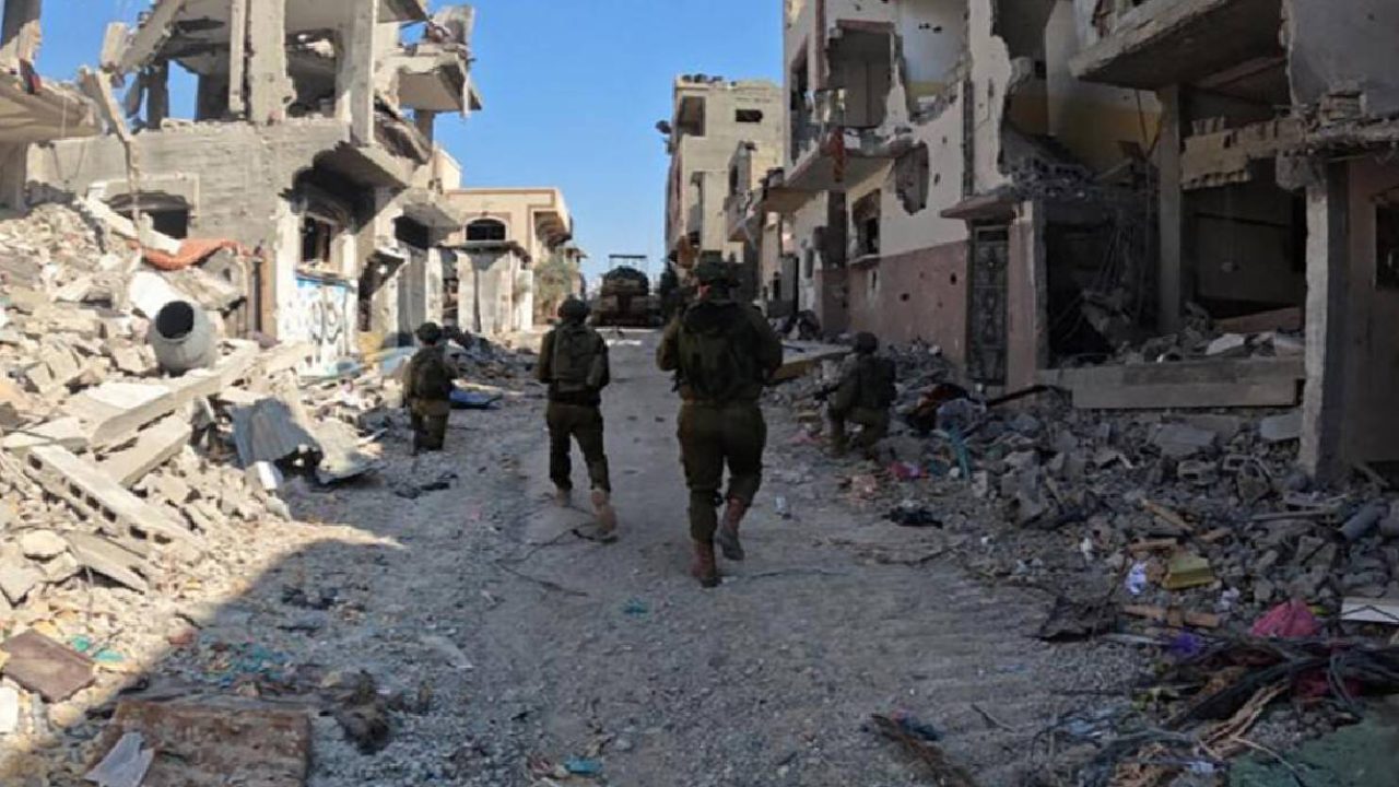 israeli soldiers marching through destroyed buildings