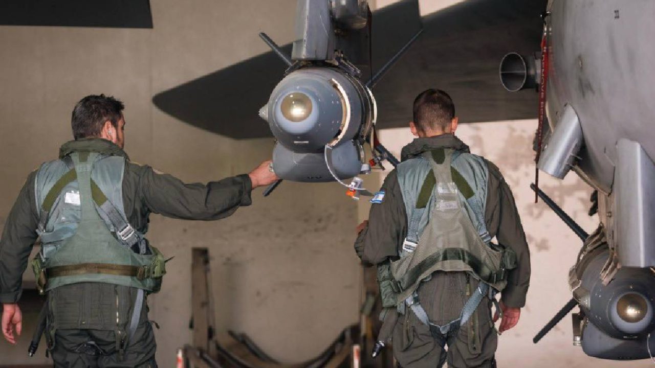 israeli soldiers with rocket attached to fighter plane